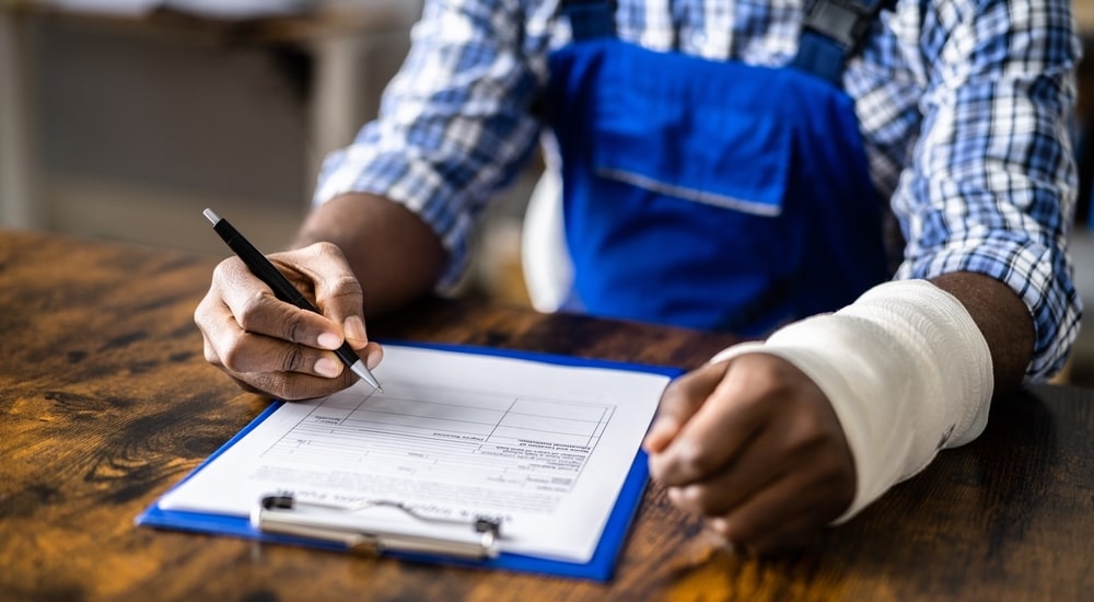 Photo of an Injured Worker Writing on a Document